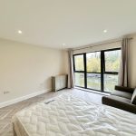 Bright bedroom overlooking canal with large windows