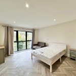 Spacious, modern bedroom with large window view.