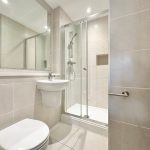 Modern bathroom with shower, sink, and toilet.