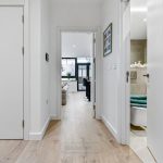 Modern hallway with bathroom and living room view.