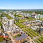 Aerial view of a modern cityscape with greenery.