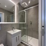Modern bathroom with shower and vanity unit.