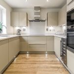 Modern kitchen with wooden flooring and appliances.