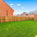 Sunny garden with brick and wood fence