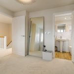 Modern hallway with mirror and bathroom view
