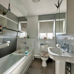 Modern bathroom with sinks, bath, and toilet.