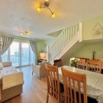 Cosy living room with dining area and stairs.