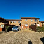 Residential houses with parked car on sunny day.