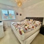 Cosy bedroom with double bed and window view.