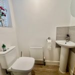 Modern bathroom with sink, toilet, and floral decor.