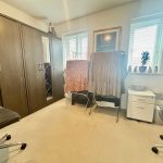 Room with wardrobes, chairs, and drying racks.