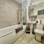 Modern bathroom with bathtub, sink, and toilet