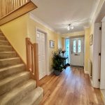 Modern hallway with staircase and plants.