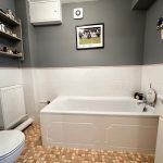 Modern bathroom with bathtub and grey walls.