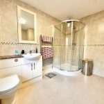 Modern bathroom with shower and toilet.