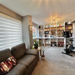 Modern living room with bookshelves and exercise bike.