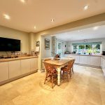 Spacious kitchen with wooden table and modern appliances.