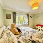 Cosy bedroom with teddy bear and toy house.