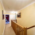 Bright hallway with wooden bannister and artwork
