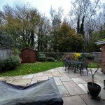Garden patio with table, chairs, and shed view.