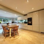 Modern kitchen with dining table and light fixtures.