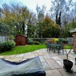 Garden with patio furniture and wooden shed.