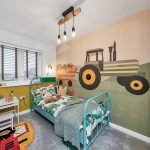 Child's bedroom with tractor mural and colourful decor.