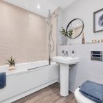 Modern bathroom with shower, sink, and framed art.