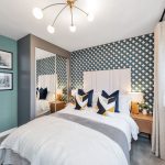 Modern bedroom with geometric wallpaper and decorative pillows.