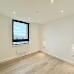 Empty room with window and wooden floor.