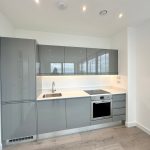 Modern kitchen with grey cabinets and appliances.