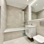 Modern bathroom with tub, vanity, and large mirror.