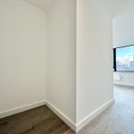 Minimalist room with wooden flooring and window view.