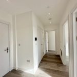 Bright hallway with wooden flooring and doors