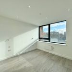 Empty room with large window and wooden floor