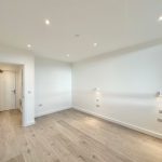 Empty room with wooden floor and white walls.