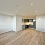 Modern kitchen in a spacious, empty apartment.