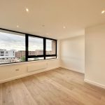 Empty modern flat with large windows.