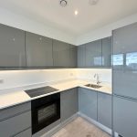 Modern kitchen with grey cabinets and white countertops.