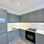 Modern kitchen with grey cabinets and appliances.