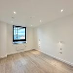 Modern empty room with wooden floor and window.