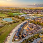 Aerial view of suburban parkland and buildings at sunset.