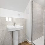 Modern bathroom with sink, shower, and toilet.