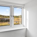 Scenic countryside view through white-framed window