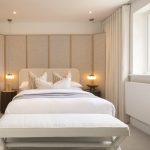 Modern beige bedroom with large window and decor