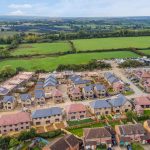 Aerial view of houses and fields in countryside.