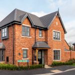 Modern red brick house on suburban street.