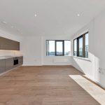 Modern kitchen with large windows and wooden floor.