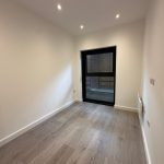 Empty room with wooden floor and window.