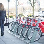 Couple walking past parked Santander rental bikes.